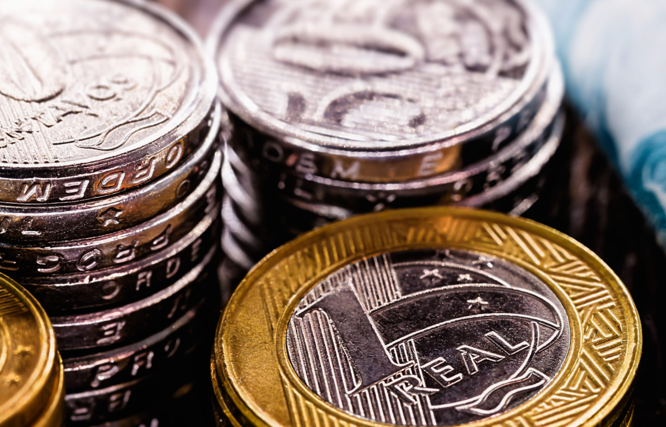 Imagem de moedas de real, ilustrando recuperação tributária e economia empresarial.